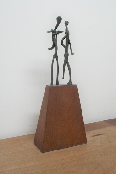 two stick figures on tall base